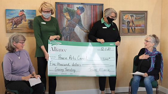 2 women presenting donation check to 2 surprised women