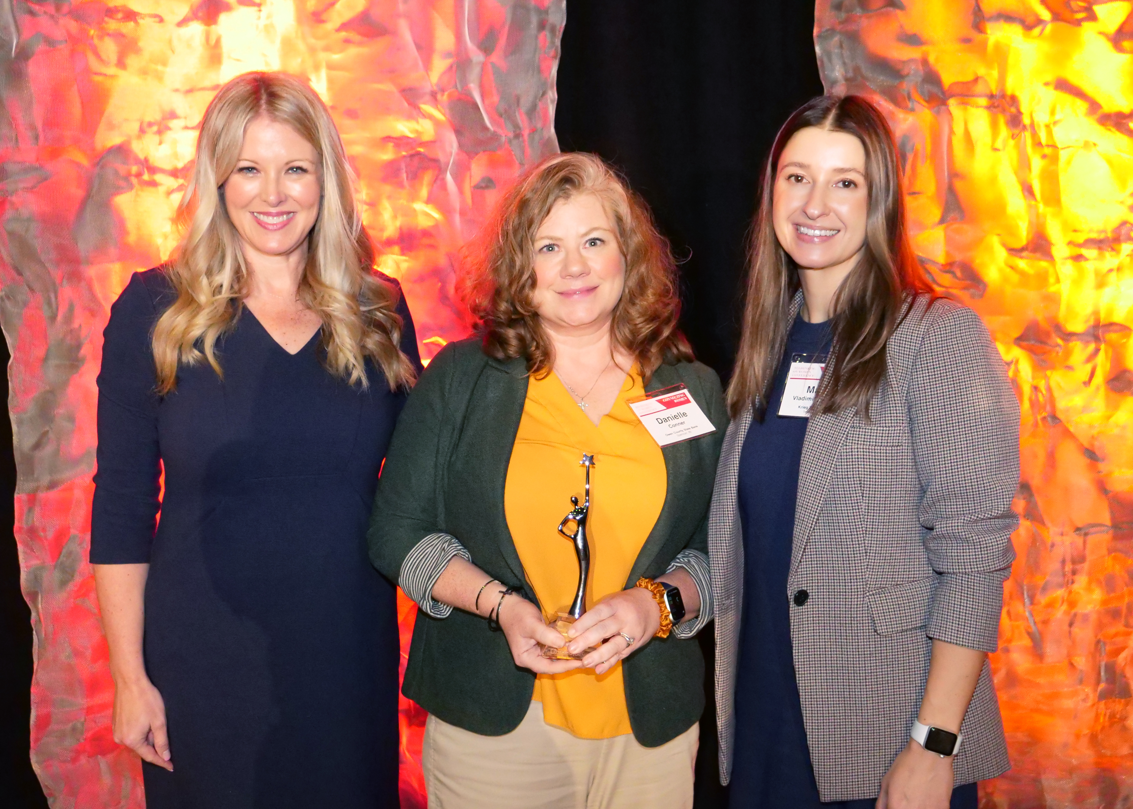 photo showing Danielle Conner posing with the 2024 IBA Woman of the Year award