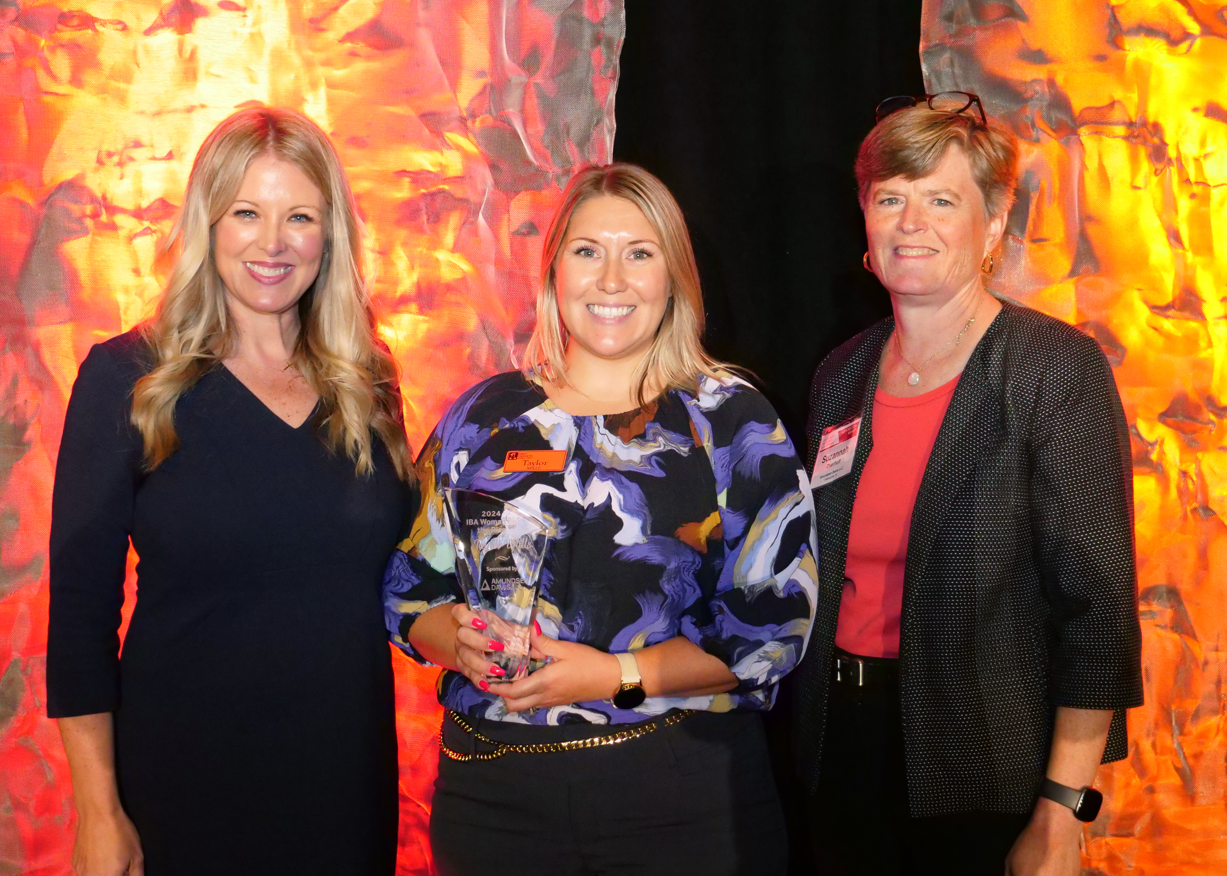 photo showing Taylor Mills posing with the 2024 IBA Woman on the Rise award